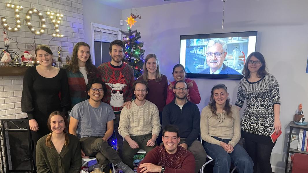 The lab at a holiday party with Tosh's face in the background